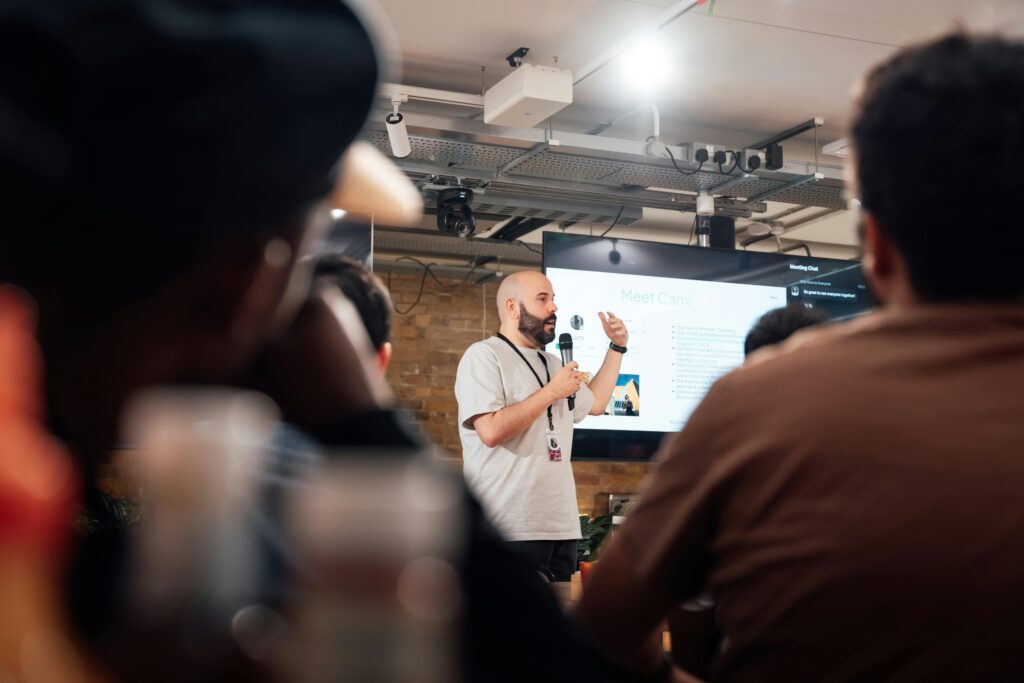 Engaging speaker presenting to an attentive audience during a tech event in London.